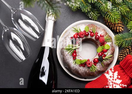 Gâteau de Noël décoré de graines de grenade, de canneberges et de romarin. Pose à plat Banque D'Images