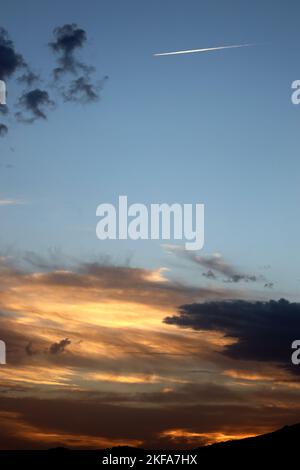 Coucher de soleil de Los Rosales près de Frailes, Jaen, Andalousie, Espagne. Nuages et coucher du soleil créant des motifs et de la couleur.avion jet stream dans le ciel du soir. Banque D'Images