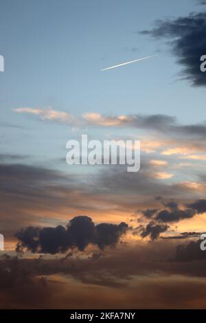 Coucher de soleil de Los Rosales près de Frailes, Jaen, Andalousie, Espagne. Nuages et coucher du soleil créant des motifs et de la couleur.avion jet stream dans le ciel du soir. Banque D'Images