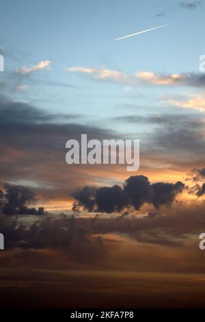 Coucher de soleil de Los Rosales près de Frailes, Jaen, Andalousie, Espagne. Nuages et coucher du soleil créant des motifs et de la couleur.avion jet stream dans le ciel du soir. Banque D'Images