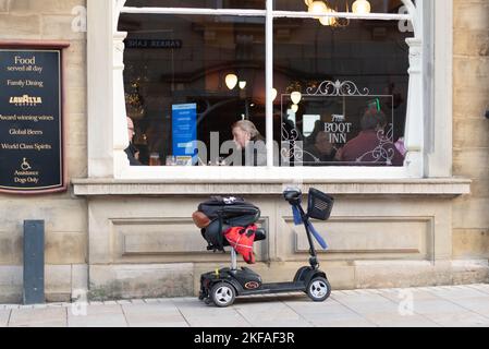 Mobility Scooter Outside Pub dans le centre-ville de Burnley avec des hommes assis dans la fenêtre Banque D'Images