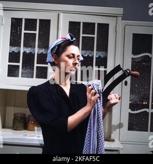 DAS Frauenzimmer, Fernsehfilm aus der Sendreihe 'as kleine Fernsehspiel', Deutschland 1981, Regie: Claudia von Alemann, Darsteller: Colleen Finneran trocknet Haushaltsgerät, ein Wiegemesser. Banque D'Images