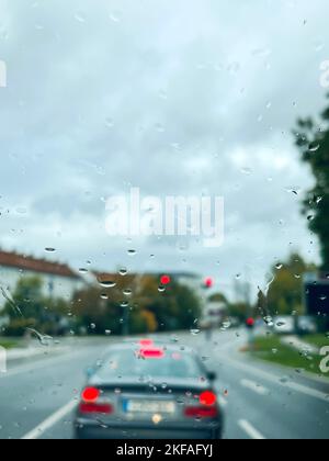 pluie, pluie tombe sur la fenêtre d'une voiture sur la route avec la circulation par temps pluvieux. véhicules sur la route visibles de derrière gouttes de pluie sur le pare-brise d'une voiture Banque D'Images