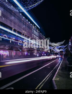 La circulation passe par le magasin de jouets de Hamley avec les décorations de noël d'ange doré sur Regent Street à Londres. Banque D'Images