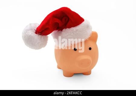 Vacances de Noël coût et économies. Tirelire avec chapeau de père Noël isolé sur fond blanc. Banque D'Images