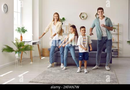 Bonne famille s'amuser avec son petit fils et sa fille dans le salon moderne. Banque D'Images