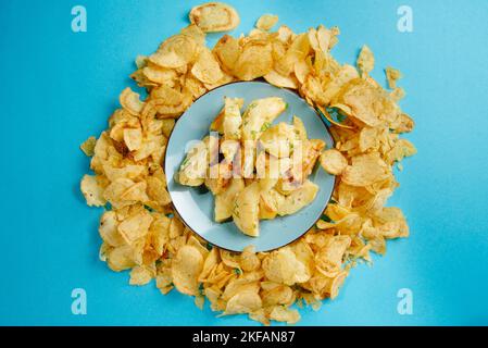 Aliments nocifs. Pommes de terre frites et frites sur fond bleu. Les aliments frits sont mauvais pour la santé Banque D'Images
