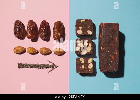 Barres de bonbons aux fruits à la date des protéines fitness avec noix et amandes de fruits et graines de pavot de chia vue de dessus sur fond bleu rose avec espace pour copier et place pour Banque D'Images