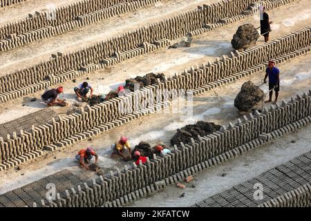 Munshigonj, Munshigonj, Bangladesh. 17th novembre 2022. Les travailleurs font des briques dans un four de briques dans le district de Munshiganj au Bangladesh. La principale matière première de la brique est l'argile. L'argile est préparée et moulée en formes rectangulaires et laissée sécher au soleil. Il y a quatre étapes pour faire des briques. Il s'agit de la préparation d'argile de brique, de la moulage de briques, du séchage de briques au soleil et de la combustion de briques au feu. Une brique pèse 5 livres. (Credit image: © Syed Mahabubul Kader/ZUMA Press Wire) Banque D'Images