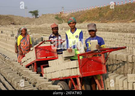 Munshigonj, Munshigonj, Bangladesh. 17th novembre 2022. Les travailleurs font des briques dans un four de briques dans le district de Munshiganj au Bangladesh. La principale matière première de la brique est l'argile. L'argile est préparée et moulée en formes rectangulaires et laissée sécher au soleil. Il y a quatre étapes pour faire des briques. Il s'agit de la préparation d'argile de brique, de la moulage de briques, du séchage de briques au soleil et de la combustion de briques au feu. Une brique pèse 5 livres. (Credit image: © Syed Mahabubul Kader/ZUMA Press Wire) Banque D'Images