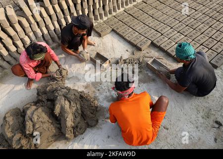 Munshigonj, Munshigonj, Bangladesh. 17th novembre 2022. Les travailleurs font des briques dans un four de briques dans le district de Munshiganj au Bangladesh. La principale matière première de la brique est l'argile. L'argile est préparée et moulée en formes rectangulaires et laissée sécher au soleil. Il y a quatre étapes pour faire des briques. Il s'agit de la préparation d'argile de brique, de la moulage de briques, du séchage de briques au soleil et de la combustion de briques au feu. Une brique pèse 5 livres. (Credit image: © Syed Mahabubul Kader/ZUMA Press Wire) Banque D'Images