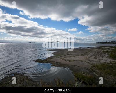 Vue vers l'ouest sur la Great South Bay et les ponts des zones humides du parc Gardiners avec des nuages sombres couvrant le soleil à la fin d'octobre. Banque D'Images