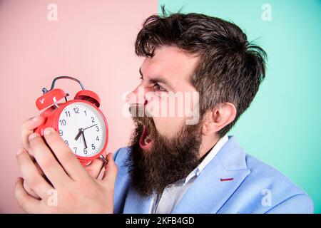 Combien de temps jusqu'à la date limite. Temps de travail. Homme barbu homme d'affaires agressif tenir horloge. Concept de contrainte. Horaire de travail stressant d'Hipster Banque D'Images