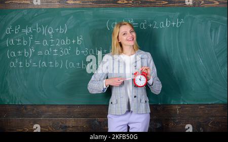 Enseignant femme tenir réveil. Elle se soucie de la discipline. Le temps d'étudier. Enseignants bienvenue année scolaire. À la recherche d'enseignants qualifiés complément engagé Banque D'Images