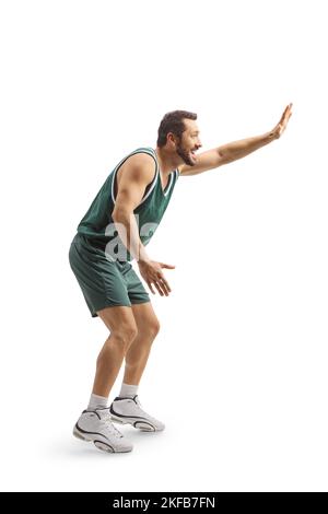 Homme dans un maillot de basket-ball jouant et faisant des gestes avec la main isolée sur fond blanc Banque D'Images