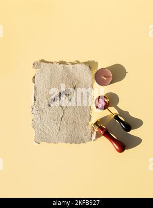 Impression de cire avec peinture au feu sur papier kraft maison avec fleurs séchées pressées. Jeu de joints d'étanchéité en cire. Banque D'Images