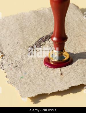 Impression de cire avec peinture au feu sur papier kraft maison avec fleurs séchées pressées. Jeu de joints d'étanchéité en cire. Banque D'Images