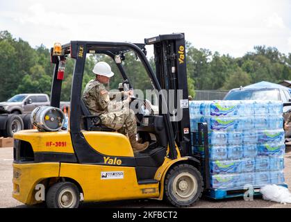 Un soldat, commandant de 66th troupes, de la Garde nationale de l'armée du Mississippi, distribue de l'eau avec un chariot élévateur à l'école moyenne Thomas Cardozo à Jackson, Mississippi, le 2 septembre 2022. Près de 600 gardes nationaux du Mississippi ont été établis sur sept sites à travers Jackson pour permettre aux gens de recueillir de l'eau en bouteille, de l'assainisseur pour les mains et de l'eau non potable dans des camions de buffles d'eau. Banque D'Images