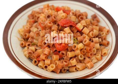 délicieux appétissant classique des pâtes à la bague macaroni avec sauce tomate et morceaux, ail, oignon, épices, huile et poivre noir et vert, foyer sélectif de a Banque D'Images