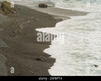 Côte de mer. Des vagues de mousse blanche s'écrasont sur le rivage. Image monochrome. La beauté et la grandeur d'une nature immaculée. Écologie, météo, loisirs en mer, beaut Banque D'Images