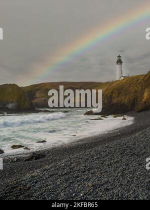 Paysage de mer pittoresque. Vagues de l'océan qui font rage, côte verte. Un arc-en-ciel multicolore dans le ciel gris. Océan après la pluie. Belle nature, ecol Banque D'Images