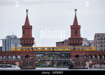 Berlin, Allemagne - septembre 2022 : magnifique vue sur le célèbre pont Oberbaum traversant la rivière Spree avec train jaune par une journée nuageux Banque D'Images