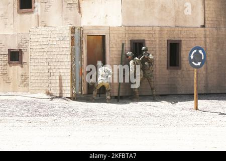 FORT IRWIN, Californie – les soldats de l'armée américaine du 11th Armored Cavalry Regiment empilent à côté d'un bâtiment en tant que coéquipier vérifie le cadre de la porte pour tout fil de voyage caché ou explosifs lors d'une démonstration de capacités militaires pour les membres du public le 2 septembre 2022, à Razish, Centre national d'entraînement à fort Irwin, en Californie, plus tard dans la journée, les soldats ont instruit les civils sur quelques techniques de base de transport de troupes et de patrouille et de nettoyage des pièces. Banque D'Images