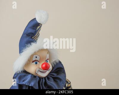 Clown blanc vintage avec poupée nez rouge dans un costume bleu avec chapeau. Des poupées en porcelaine sont apparues au 18th siècle en France. Ils ont été utilisés pour promouvoir Fren Banque D'Images