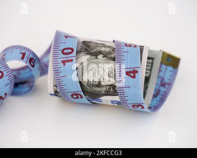 Un billet de cent dollars avec une mètre ruban enroulé autour de lui. Gros plan. Banque D'Images