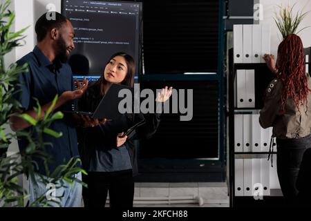 Équipe diversifiée de programmeurs analysant le code html sur ordinateur portable, en vérifiant le projet d'intelligence artificielle dans le bureau informatique. Développeurs d'applications travaillant sur des logiciels d'apprentissage machine, développant une nouvelle interface. Banque D'Images