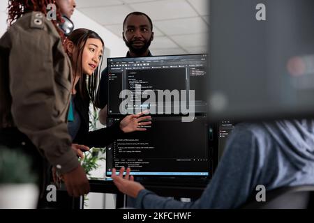 Équipe d'ingénieurs système écrivant des données et discutant du langage de codage, analysant le code du serveur et la base de données. Les ingénieurs INFORMATIQUES travaillant avec la fenêtre de terminal du cloud computing dans la société de logiciels Banque D'Images