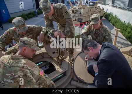 L'honorable Doulgas Bush, secrétaire adjoint de l'armée américaine pour l'acquisition, la logistique, Et la technologie, regarde à l'intérieur d'un char de bataille de l'armée américaine M1A2 Abrams avec le remeur d'armure de chars, affecté à la compagnie Bravo, 1st Bataillon, 68 Armored Regiment, 3rd Armored Brigade combat Team, 4th Infantry Division, lors de l'exposition annuelle de l'industrie de défense internationale 30th à Kielce, Pologne, le 7 septembre 2022. Des salons commerciaux comme le MPSO offrent une occasion unique au ministère de la Défense des États-Unis et à l'industrie de la défense de s'engager avec des alliés et des partenaires, et de démontrer certaines de ses capacités. Banque D'Images
