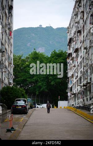 Vue verticale d'une personne se trouvant dans une rue entre deux anciens logements publics dans le domaine Tai Hang Sai à Shek Kip Mei, Hong Kong Banque D'Images