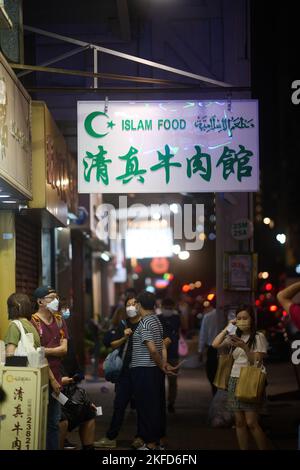 Personnes avec des masques en file d'attente à la commande d'un restaurant halal à Kowloon City, Hong Kong.Traduction: Halal Beef Restaurant Banque D'Images