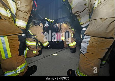 Le colonel Taona Enriquez, à gauche, commandant de l'installation et Sgt. Alan Weary, chef du commandement de l'installation, se prépare à porter une victime d'incendie simulée pendant la formation de lutte contre l'incendie à la base aérienne de Hanscom, Mass., septembre 8. Le Service des incendies de la Division du génie civil de 66th a accueilli les dirigeants pour démontrer ce que les pompiers ont vécu pendant la formation et les événements réels. Banque D'Images