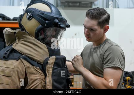 Le premier Airman Hunter Rudnik, un technicien en élimination des munitions explosives affecté à l'escadron du génie civil expéditionnaire 380th, assure la sécurité du Sgt d'état-major. Raul “Adrian” Ayala, dans un procès à la bombe lors d’un défi aux rayons X 8 septembre 2022, à la base aérienne Al Dhafra, aux Émirats arabes Unis. Les techniciens EOD utilisent des dispositifs de ciblage des rayons X pour voir le contenu des emballages suspects qui peuvent contenir des dispositifs explosifs. Banque D'Images