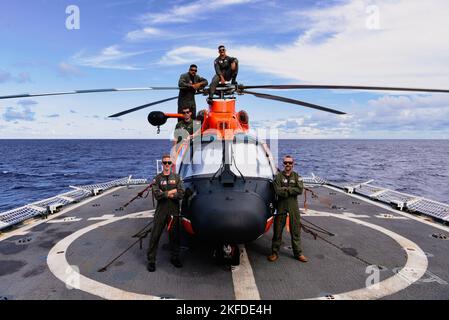 Les membres d'équipage affectés à la station aérienne de la Garde côtière Houston et Miami posent pour une photo de l'hélicoptère MH-65 Dolphin à bord du Mohawk de l'USCGC (WMEC 913) alors qu'il est en cours dans l'océan Atlantique, le 9 septembre 2022. Un détachement d'aviation a été temporairement déployé avec les Mohawks pour une patrouille AFRICOM de 3 mois. Banque D'Images