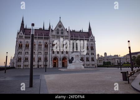 Une photo en petit angle du Parlement hongrois avec une statue sur le devant de la scène à Budapest Banque D'Images
