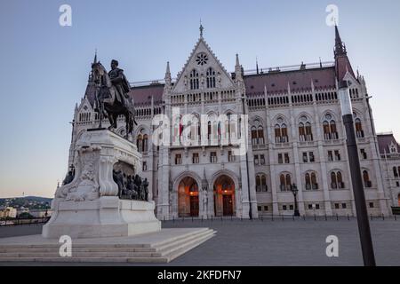 Une photo en petit angle du Parlement hongrois avec une statue sur le devant de la scène à Budapest Banque D'Images