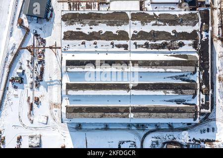 vue aérienne de dessus de la zone industrielle en hiver. bâtiment d'usine et entrepôts couverts de neige. Banque D'Images