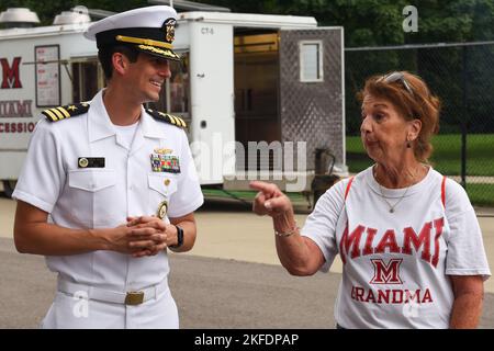 220909-N-FP878-0005 OXFORD, OHIO (SEP. 10, 2022) - Cmdr. Erik Moss, directeur général de Navy Talent Acusition Group Ohio River Valley (NTAG ORV), parle avec un patron du match Miami contre Rober Morris au Yager Stadium. NTAG ORV couvre l'Ohio, la Virginie occidentale du Kentucky et certaines parties d'Indianna pour le recrutement et la liaison de la Marine pour les zones de concentration de la flotte d'Aon. Banque D'Images