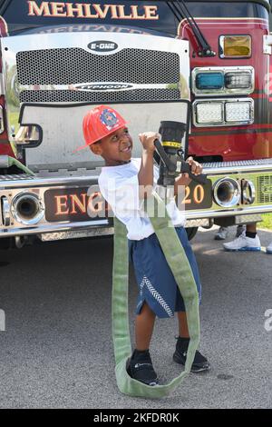 Un membre de la famille de la 131st Bomb Wing pose avec un feu de cheminée pendant la journée familiale à la base de la Garde nationale aérienne Jefferson Barracks, St. Louis, Missouri, le 10 septembre 2022. Le service des incendies de Mehlville, Missouri, a généreusement fait don de son temps et de son équipement, fournissant à la fois un moteur et un véhicule d'intervention d'urgence. Banque D'Images