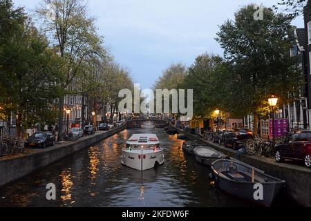 Un bateau touristique sur un canal d'Amsterdam au crépuscule, Amsterdam, pays-Bas Banque D'Images