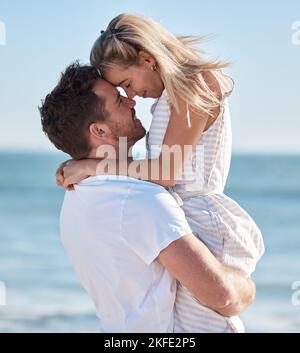 Plage, couple et hug, levage et amour, soin et date romantique, vacances d'été et vacances de soleil. Couple heureux, homme et femme à l'océan, liberté Banque D'Images