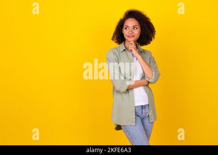 Photo portrait de charmante jeune fille cheveux ondulés créer plan look vide espace porter chemise kaki élégante isolée sur fond jaune Banque D'Images