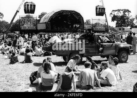 CROWD, HEATWAVE, NME STAGE, GLASTONBURY 95 : les festivaliers s'écrasent sur l'herbe dans la canicule estivale extrême au deuxième NME Stage Field et la foule au Glastonbury Festival, Pilton Farm, Somerset, Angleterre, 24 juin 1995. En 1995, le festival a célébré son 25e anniversaire. Beaucoup de gens ont lutté avec un coup de chaleur lors du week-end particulièrement chaud. Photo : ROB WATKINS Banque D'Images