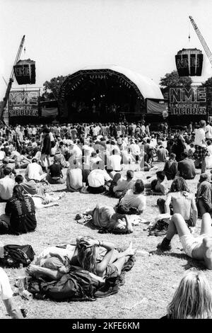 CROWD, HEATWAVE, NME STAGE, GLASTONBURY 95 : les festivaliers s'écrasent sur l'herbe dans la canicule estivale extrême au deuxième NME Stage Field et la foule au Glastonbury Festival, Pilton Farm, Somerset, Angleterre, 24 juin 1995. En 1995, le festival a célébré son 25e anniversaire. Beaucoup de gens ont lutté avec un coup de chaleur lors du week-end particulièrement chaud. Photo : ROB WATKINS Banque D'Images