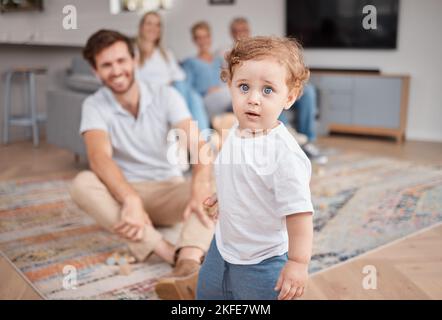 Bébé, portrait et jouer dans le salon avec la famille, curieux et énergie, mignon et petit avec papa, maman et grands-parents. Garçon , mère et père Banque D'Images