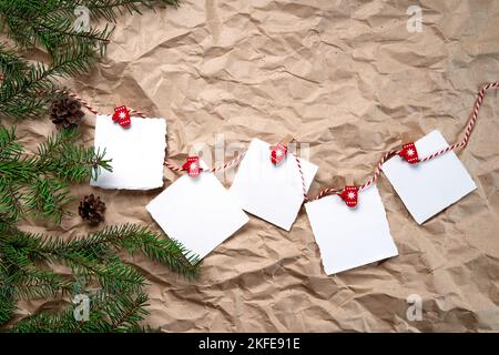 Carnets blancs sur un fond de nouvel an . Bonne année et Joyeux Noël. Objectifs du nouvel an ou promesses avec des décorations colorées sur fond de papier kraft froissé avec branches d'arbre de Noël. Par le dessus, poser à plat. Banque D'Images