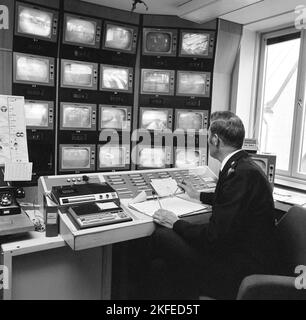 La sécurité du métro en 1970s. Le flux des caméras de surveillance du métro est surveillé. Un homme dans la salle de contrôle a de nombreux moniteurs différents devant lui et son travail est d'alerter la sécurité, la police ou l'ambulance s'il voit quelque chose se produire. Suède 1970s. Kristoffersson Banque D'Images